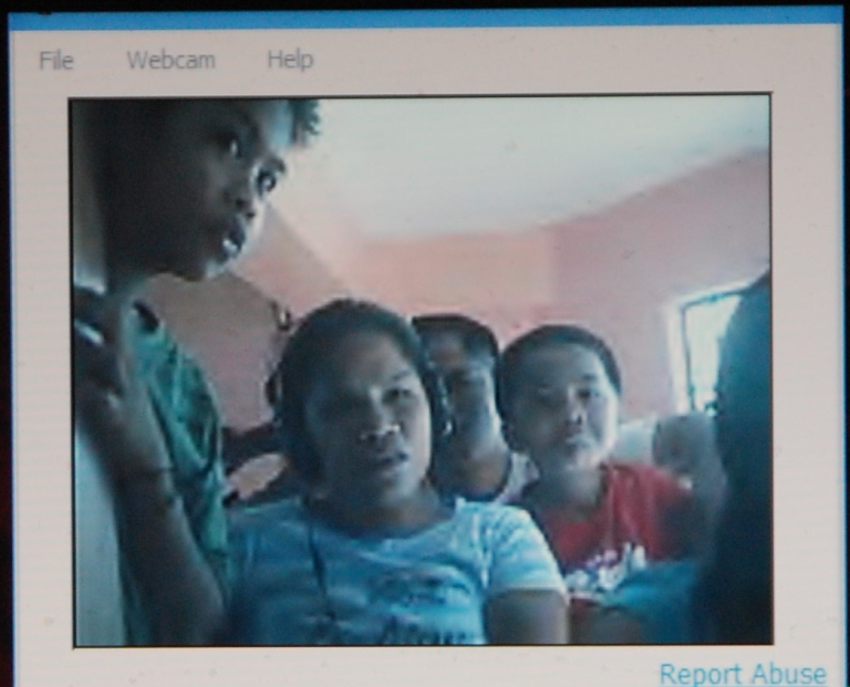 The Saldana Families of Leyte use an Internet Cafe webcam to see their sist...